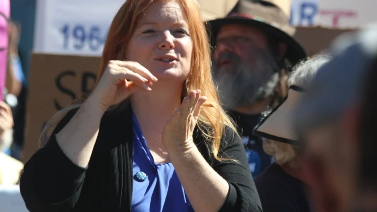 ASL interpreter signing on camera, the core of ASL video translation, framed from mid-torso up